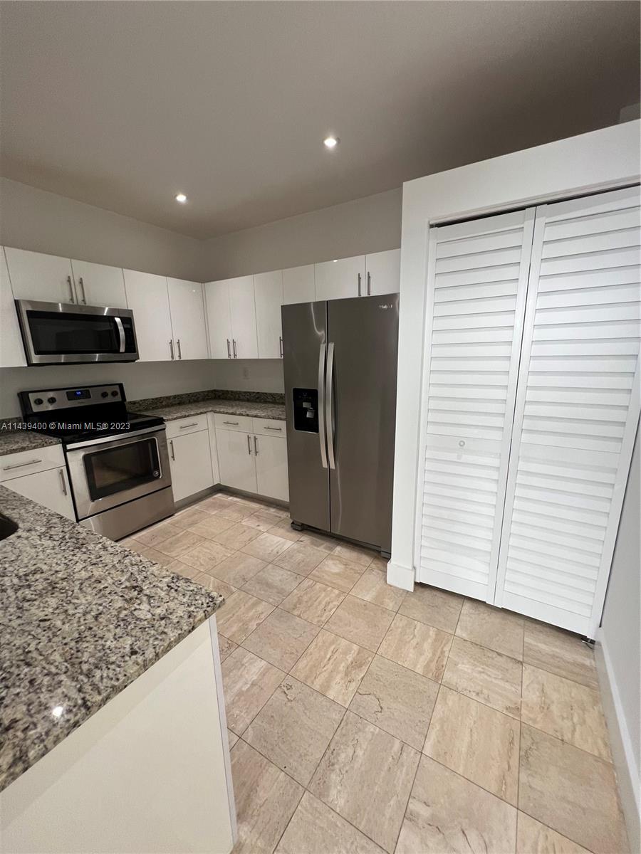 1915 Brickell Avenue, Unit TH16 Miami, FL 33129 - Photo 9 of 36 a kitchen with stainless steel appliances granite countertop a refrigerator and a stove top oven