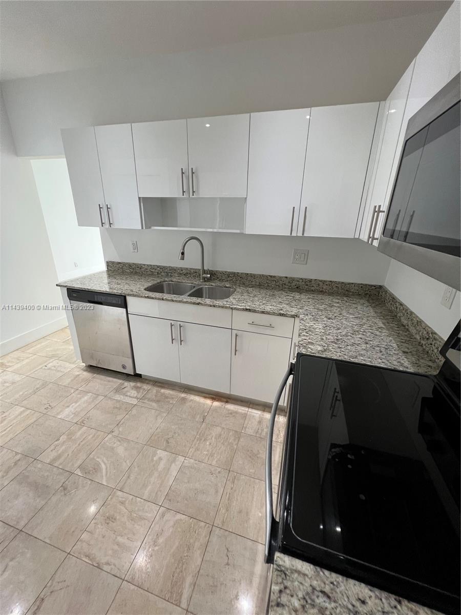 1915 Brickell Avenue, Unit TH16 Miami, FL 33129 - Photo 10 of 36 a kitchen with granite countertop a sink a stove and cabinets