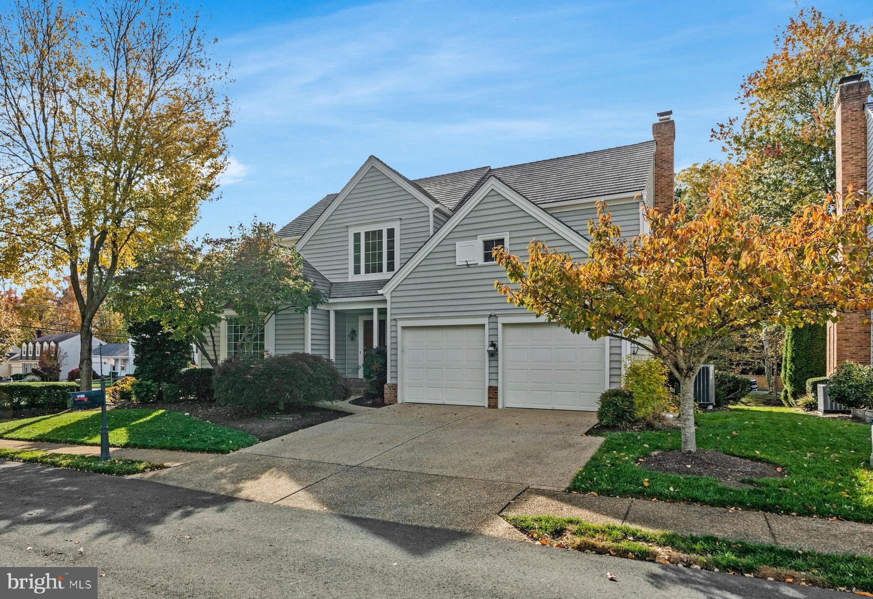 9733 Hidden Valley Road Vienna, VA 22181 - Photo 1 of 11 a front view of a house with a garden and trees