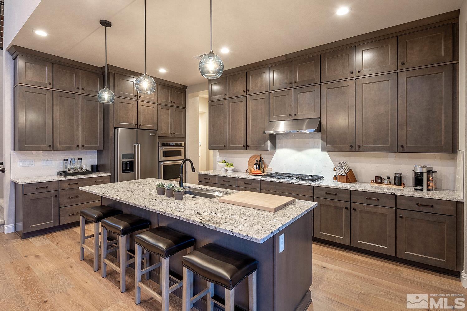 5414 Cremello Way Reno, NV 89511 - Photo 19 of 40 a kitchen with granite countertop a sink a center island and cabinets