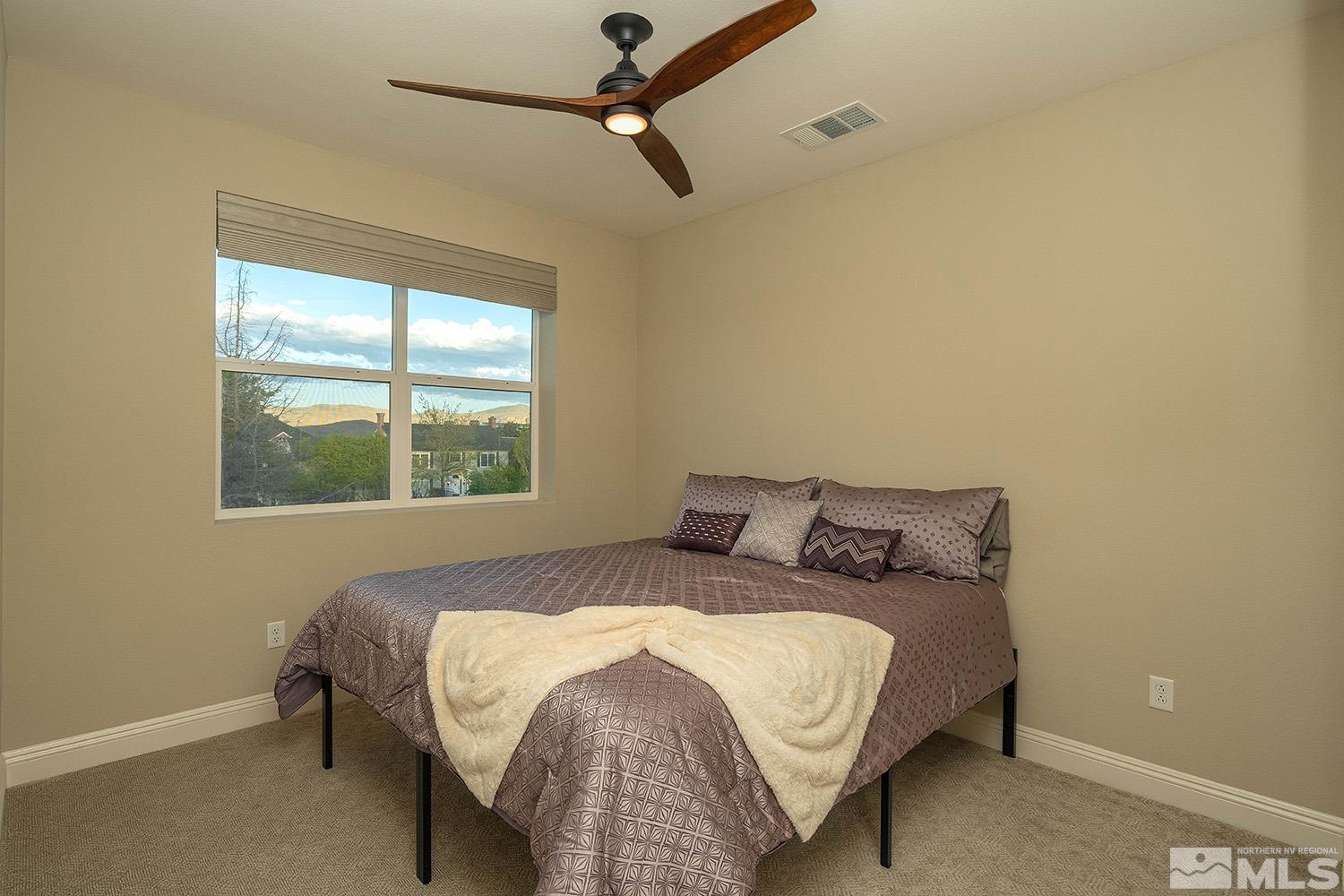 5414 Cremello Way Reno, NV 89511 - Photo 34 of 40 a bed sitting in a bedroom next to a window