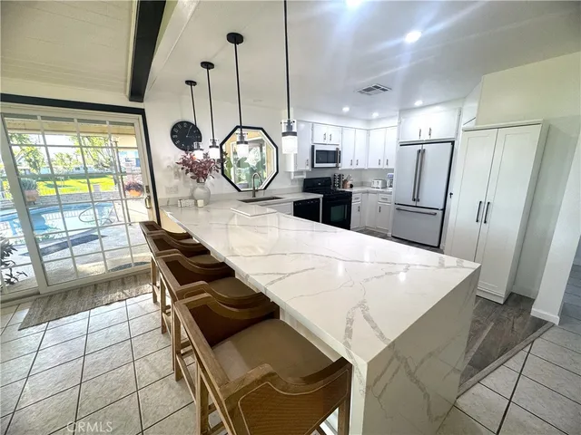 a kitchen with stainless steel appliances kitchen island granite countertop a stove a sink and a microwave