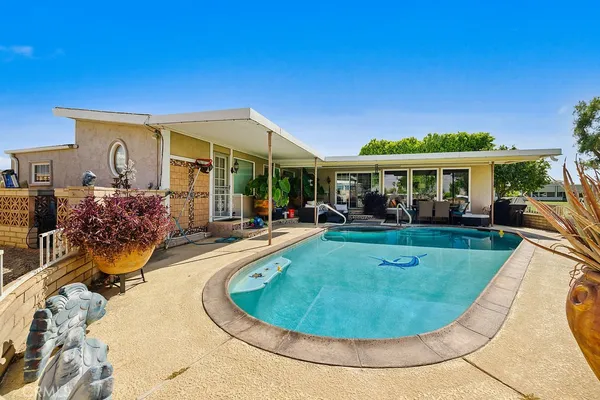 a view of a house with swimming pool and sitting area