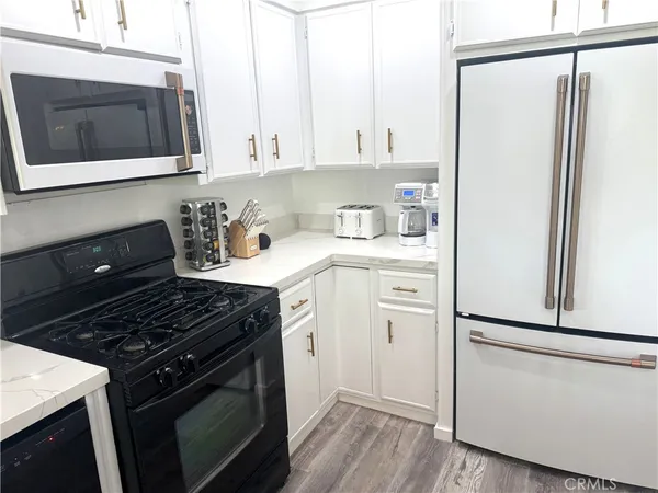 a kitchen with stainless steel appliances granite countertop a stove a refrigerator and a microwave