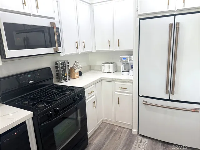 a kitchen with stainless steel appliances granite countertop a stove a refrigerator and a microwave