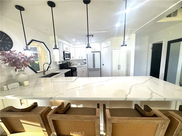 a room with kitchen island stainless steel appliances lots of countertop furniture