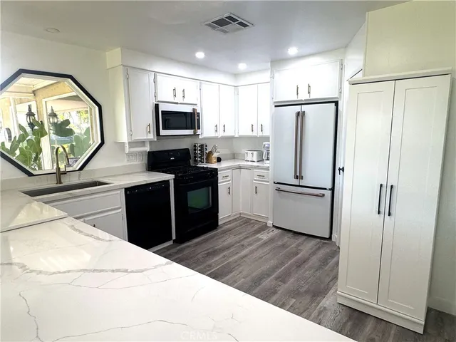 a kitchen with stainless steel appliances a refrigerator stove microwave and sink