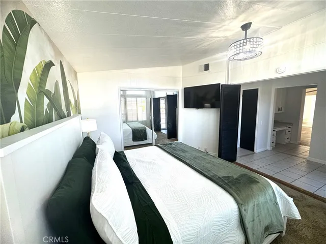 a spacious bedroom with a bed and a chandelier