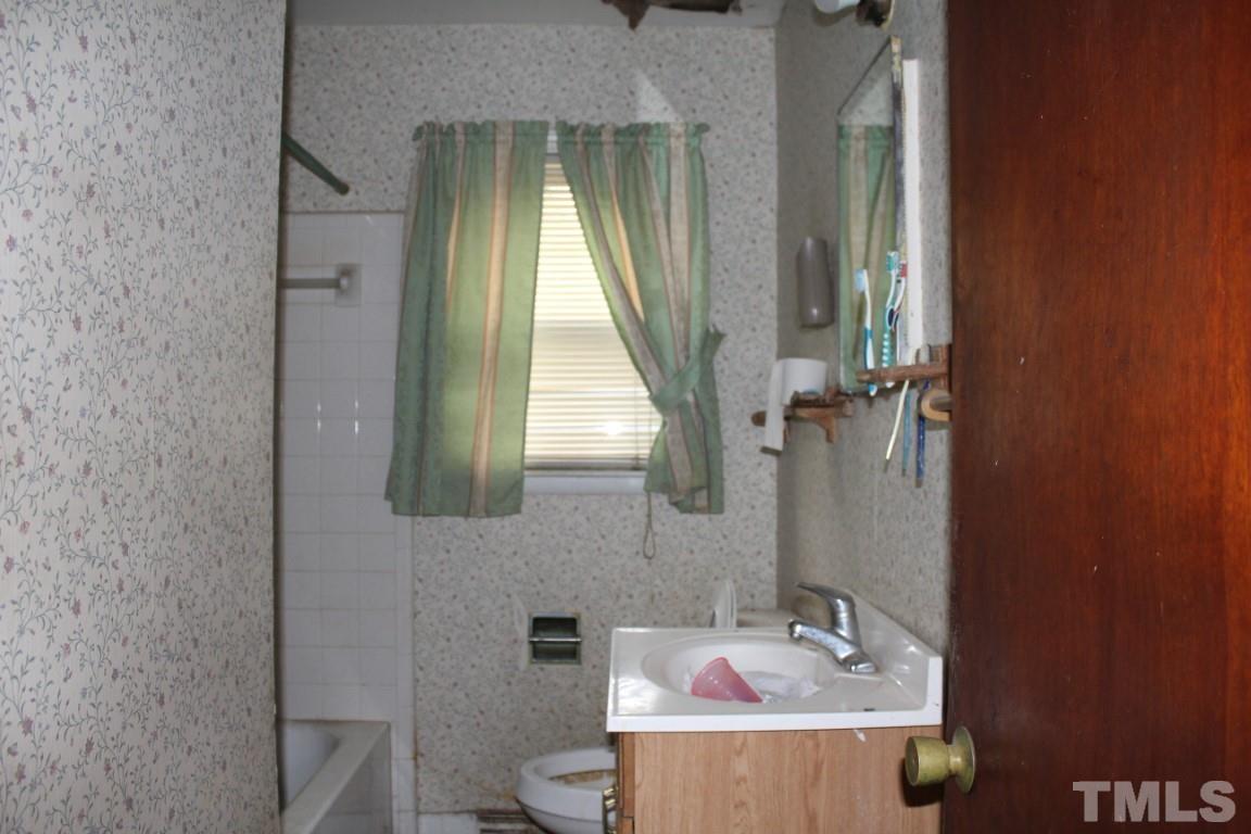 1811 Charles Street Raleigh, NC 27610 - Photo 11 of 16 a bathroom with a sink mirror vanity and toilet
