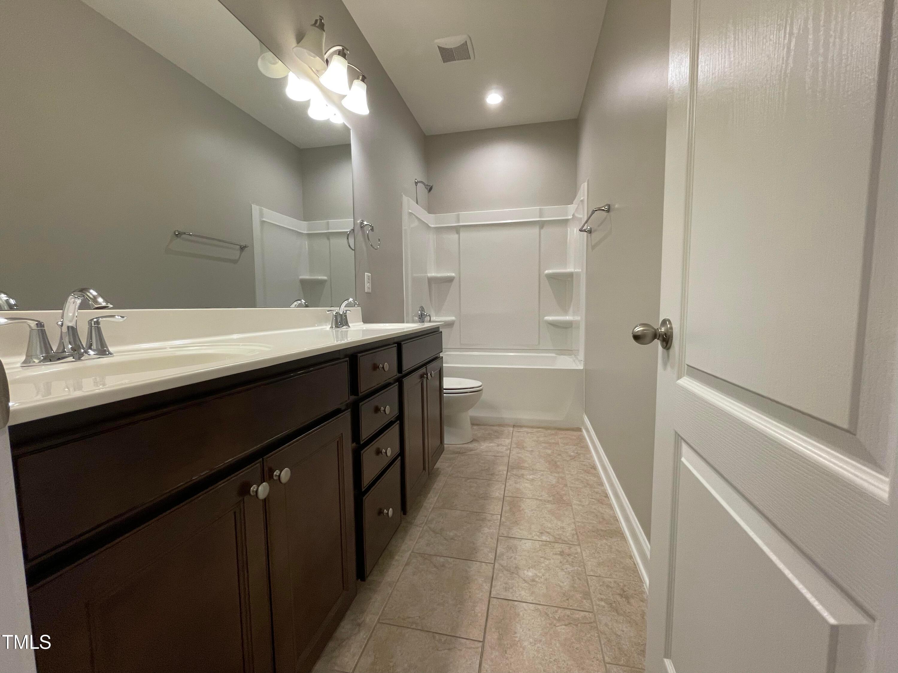 1809 Capstone Drive Durham, NC 27713 - Photo 20 of 35 a bathroom with a sink a mirror and a shower