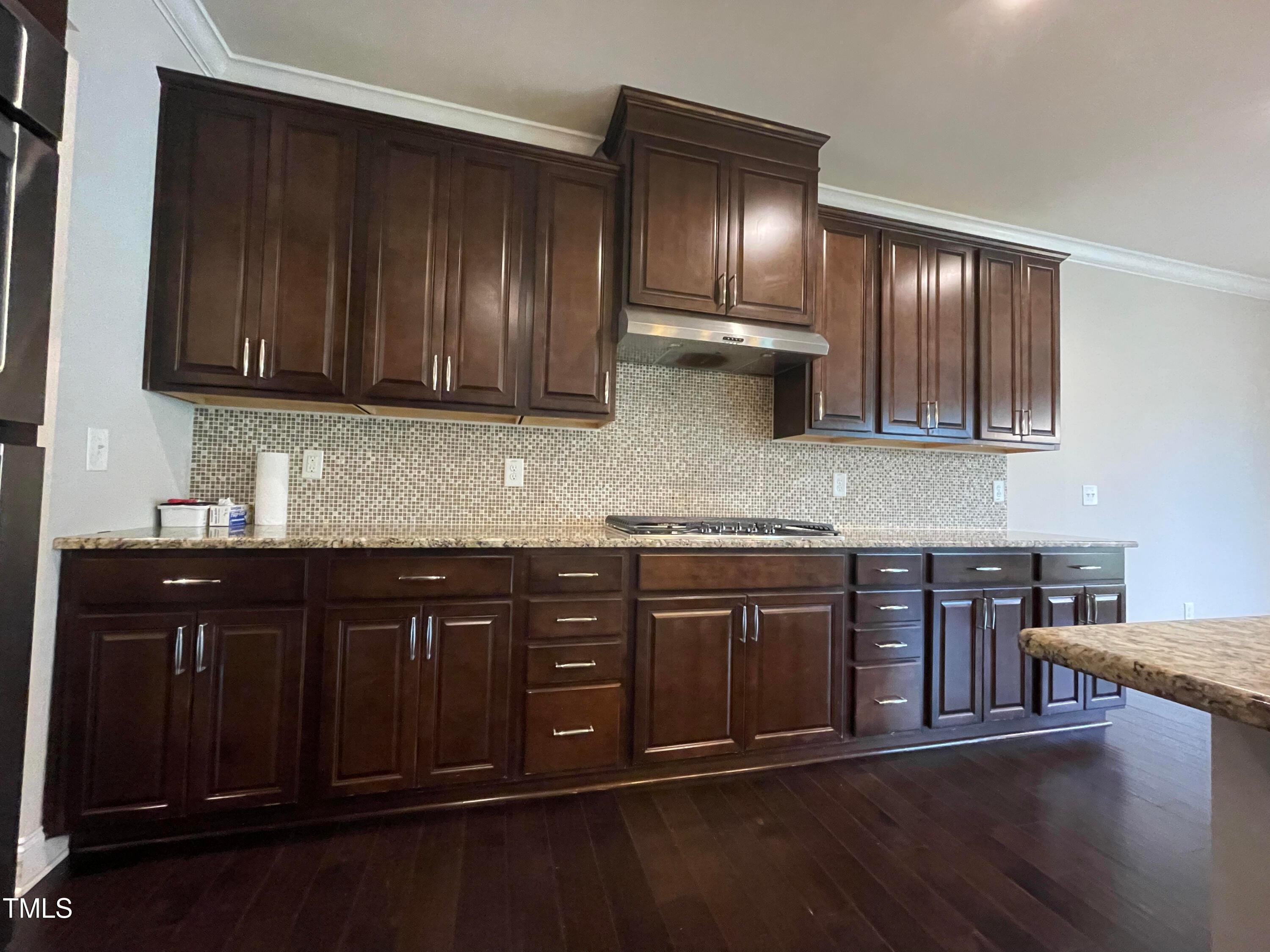 1809 Capstone Drive Durham, NC 27713 - Photo 9 of 35 a kitchen with stainless steel appliances granite countertop wooden cabinets a stove top oven with wooden floor