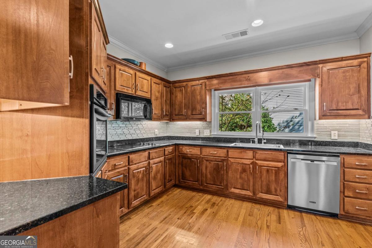 1540 Vintage Club Road Greensboro, GA 30642 - Photo 27 of 71 a kitchen with stainless steel appliances granite countertop sink stove and cabinets