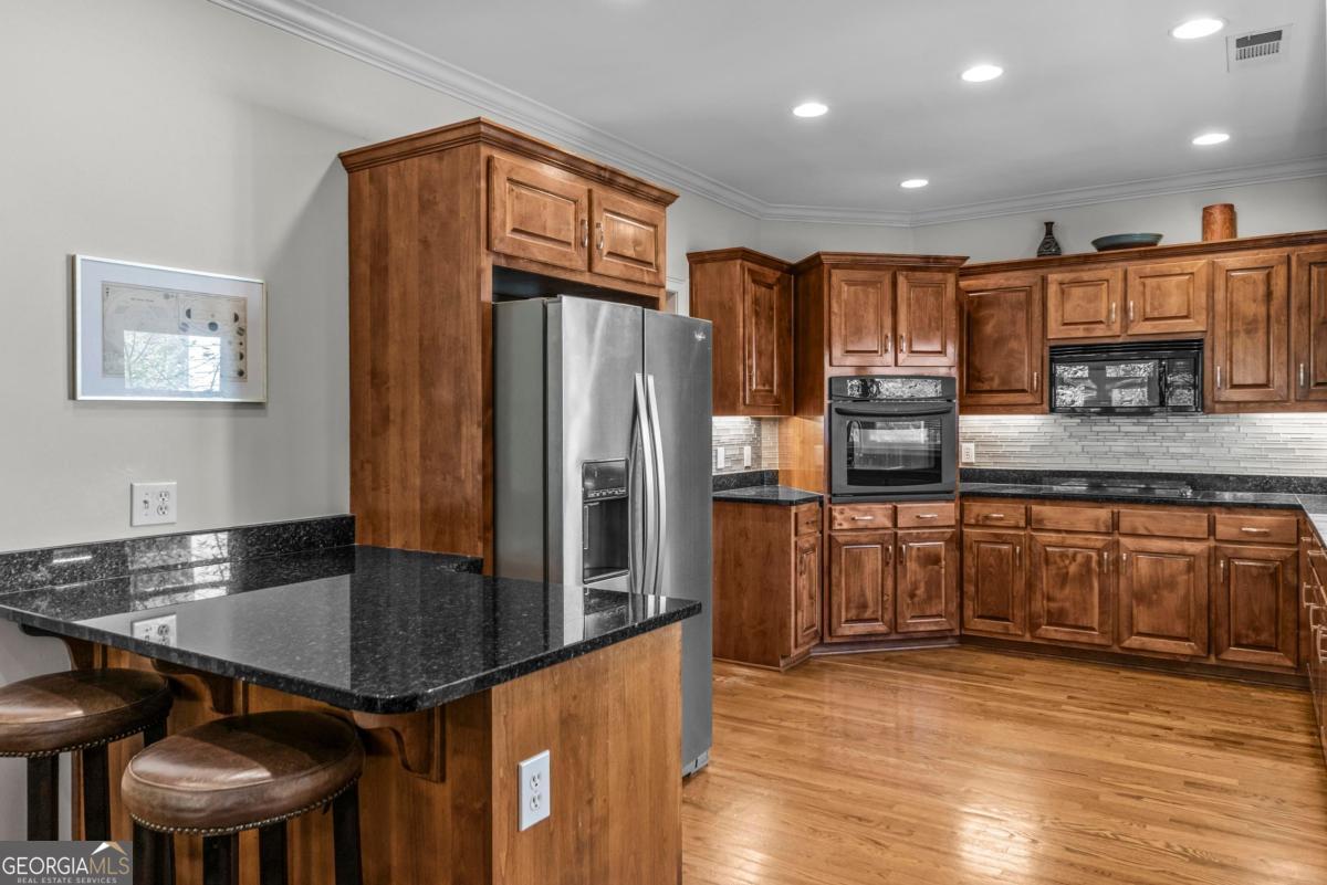 1540 Vintage Club Road Greensboro, GA 30642 - Photo 34 of 71 a kitchen with stainless steel appliances granite countertop a refrigerator a stove and a wooden cabinets