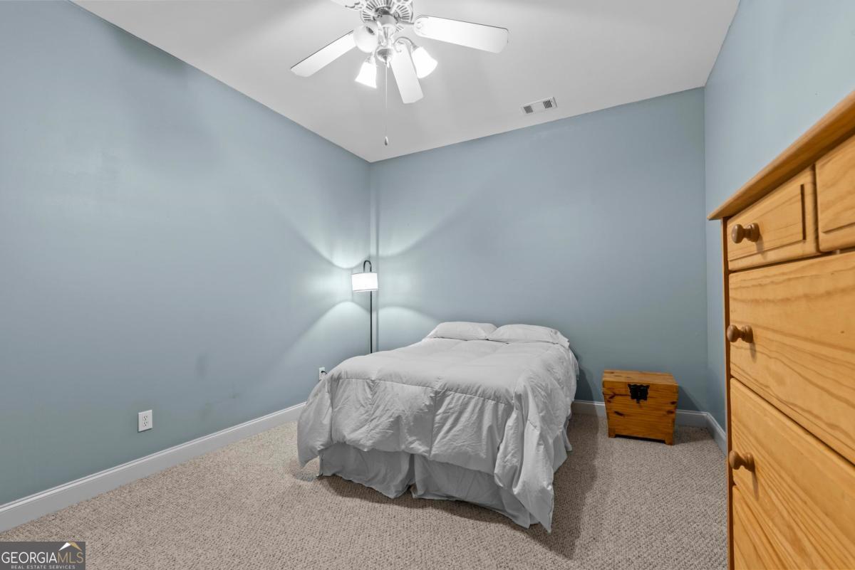 1540 Vintage Club Road Greensboro, GA 30642 - Photo 54 of 71 a bedroom with a bed and a chandelier