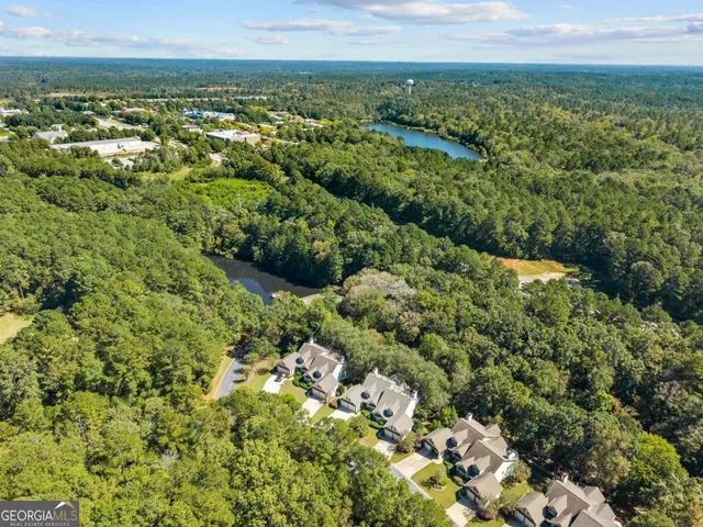 an aerial view of residential house with outdoor space and trees all around