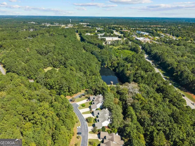 an aerial view of residential houses with outdoor space and trees