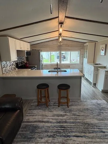 a kitchen with stainless steel appliances granite countertop a sink and a refrigerator