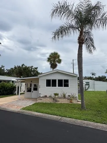 a front view of a house with a garden and a tree