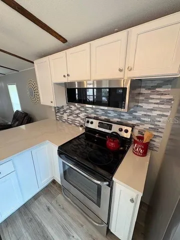 a kitchen with stainless steel appliances a stove a microwave and a refrigerator
