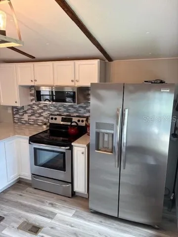 a kitchen with stainless steel appliances granite countertop a stove a refrigerator and a microwave