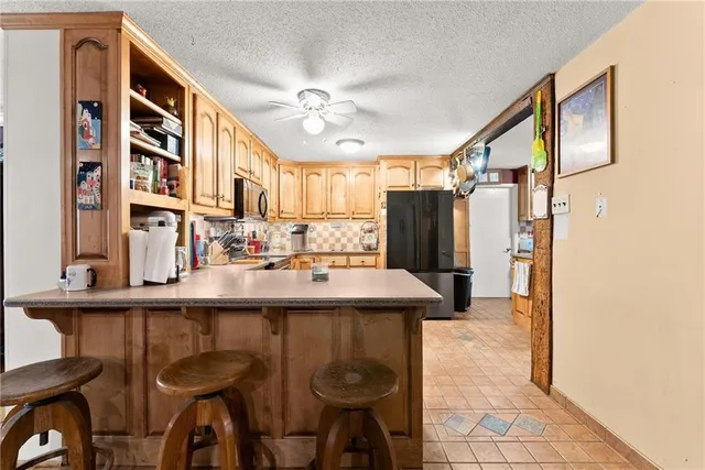 a kitchen with stainless steel appliances granite countertop a refrigerator and a stove top oven