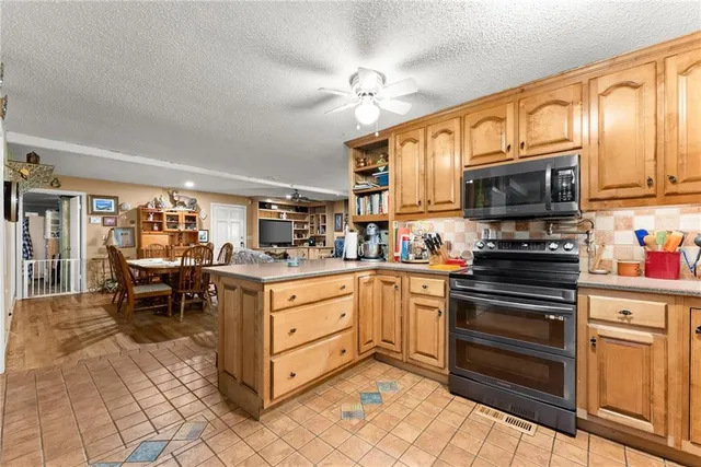 a kitchen with stainless steel appliances granite countertop a sink and refrigerator