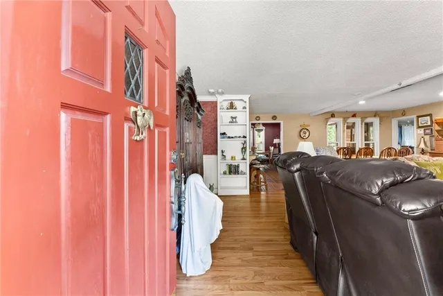 a living room with furniture and a flat screen tv with kitchen view