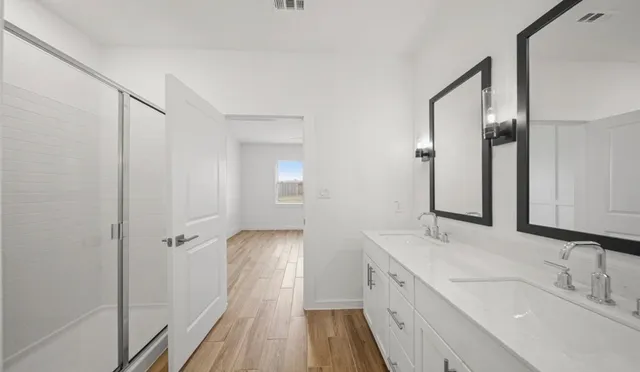 a spacious bathroom with a double vanity sink and a mirror