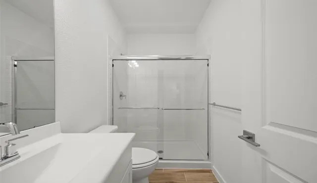 a bathroom with a sink a toilet and shower