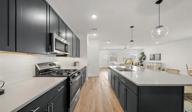 a kitchen with a sink stainless steel appliances a counter space and cabinets