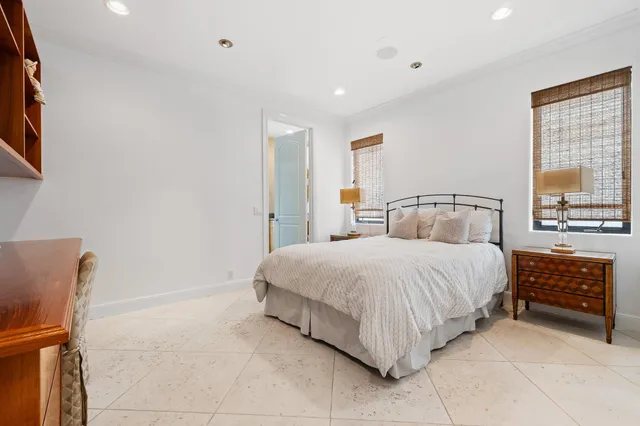 a bedroom with a bed mirror and window