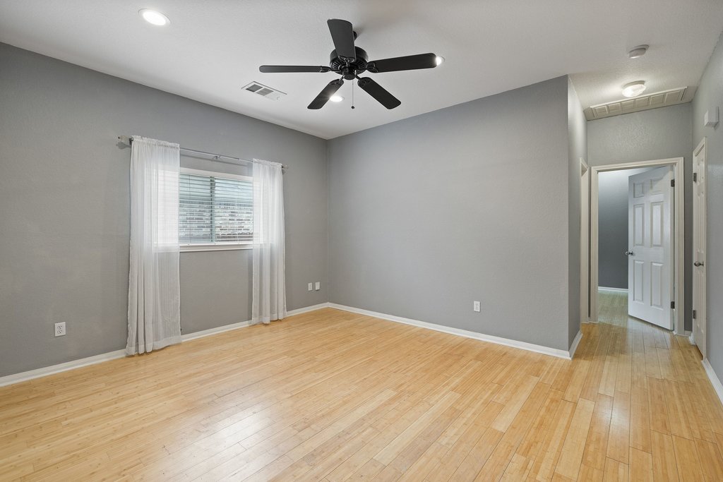 347 Spring Drive Kyle, TX 78640 - Photo 6 of 40 Well-lit room with wood flooring and a refreshing ceiling fan.