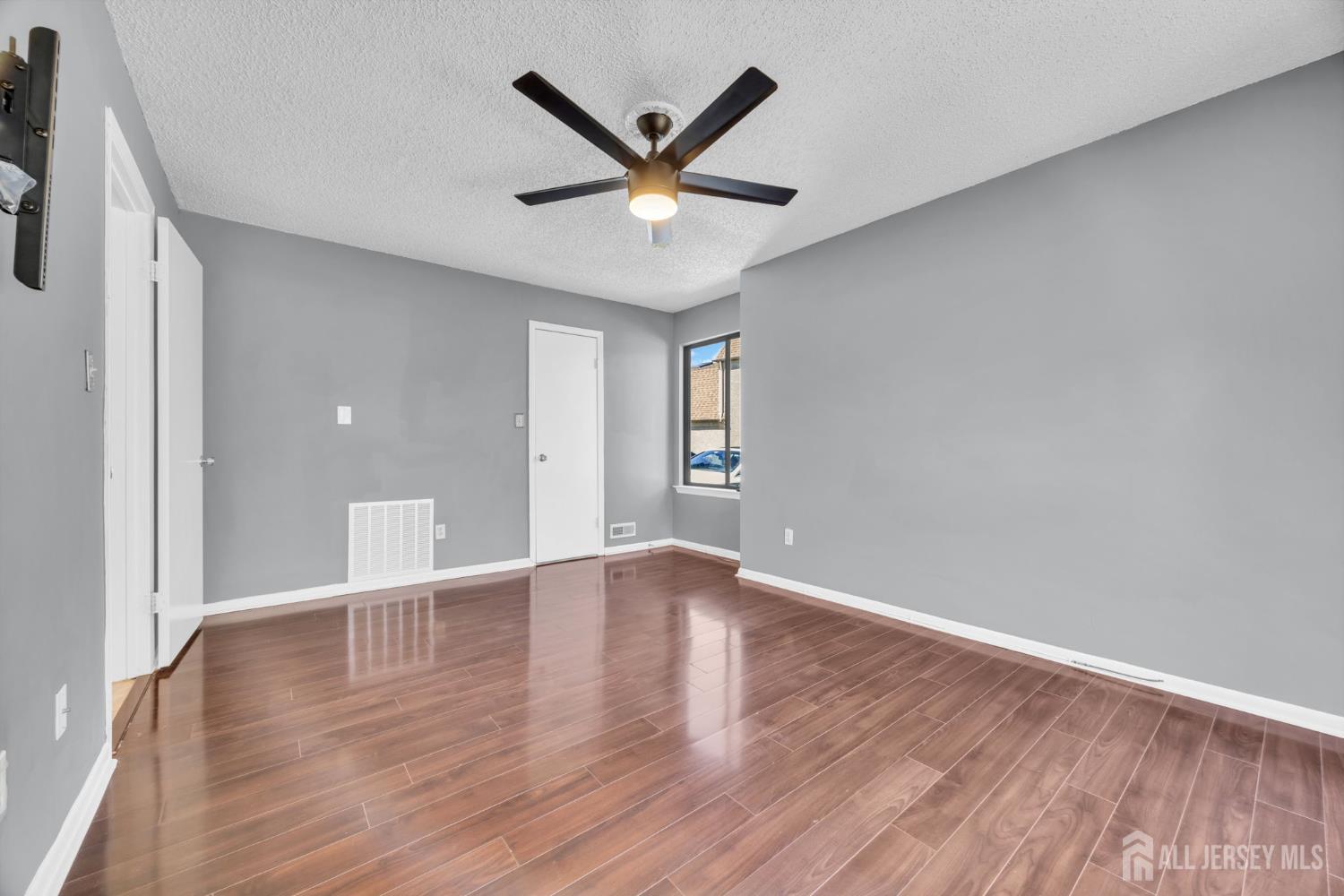 9 Carriage Place Edison, NJ 08820 - Photo 14 of 21 a view of an empty room with window and wooden floor