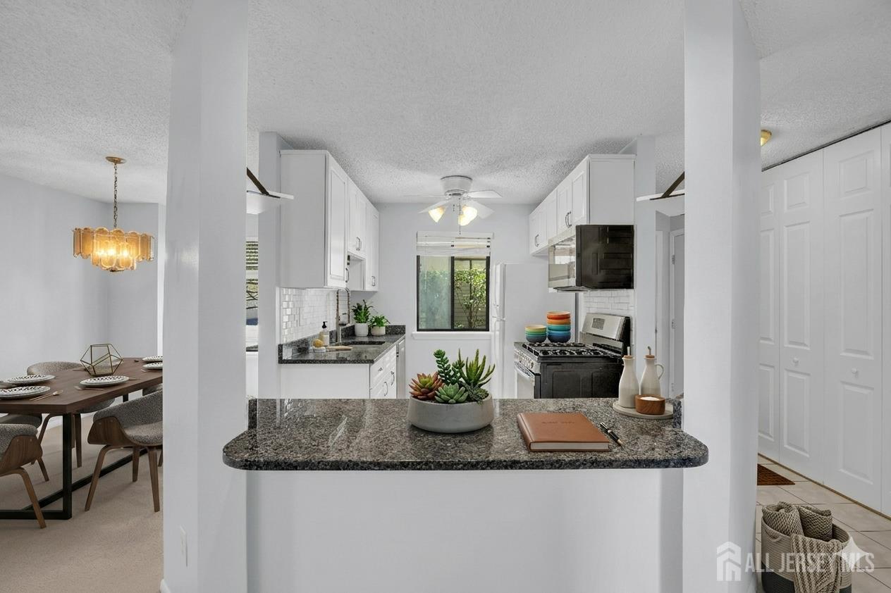 9 Carriage Place Edison, NJ 08820 - Photo 4 of 21 a kitchen with stainless steel appliances granite countertop a sink and a microwave