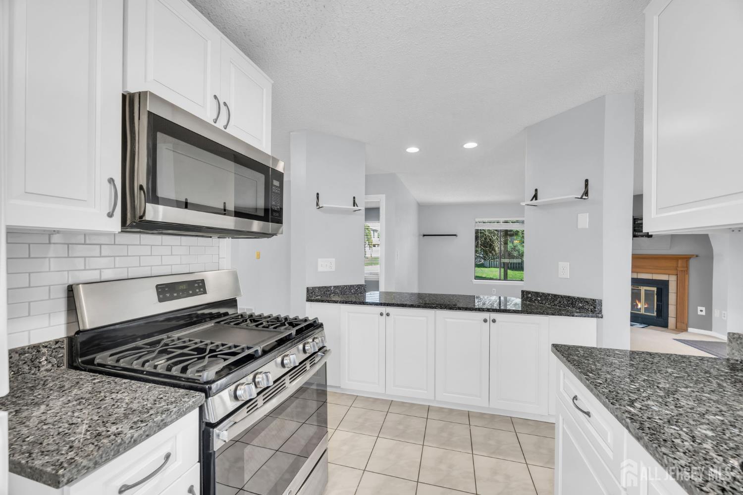 9 Carriage Place Edison, NJ 08820 - Photo 5 of 21 a kitchen with stainless steel appliances granite countertop a stove top oven a sink dishwasher and a microwave oven with white cabinets