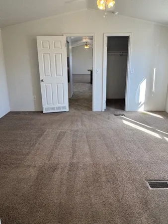 an empty room with a window and a kitchen