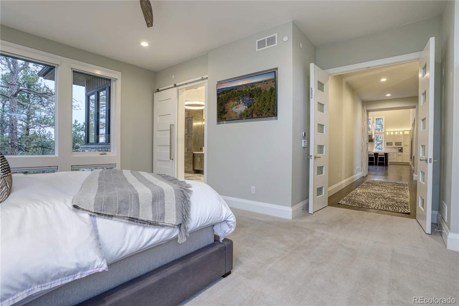 7865 Forest Keep Circle Parker, CO 80134 - Photo 18 of 40 a spacious bedroom with a bed and glass door
