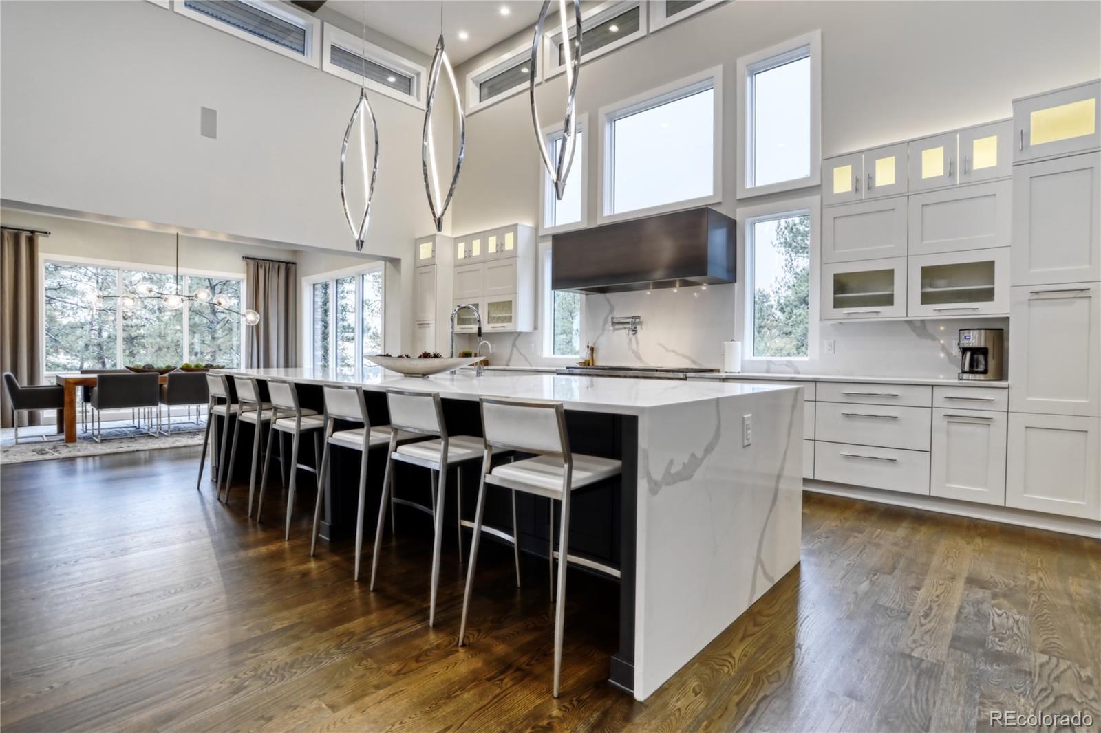7865 Forest Keep Circle Parker, CO 80134 - Photo 3 of 40 a open kitchen with stainless steel appliances kitchen island granite countertop a table chairs and a refrigerator