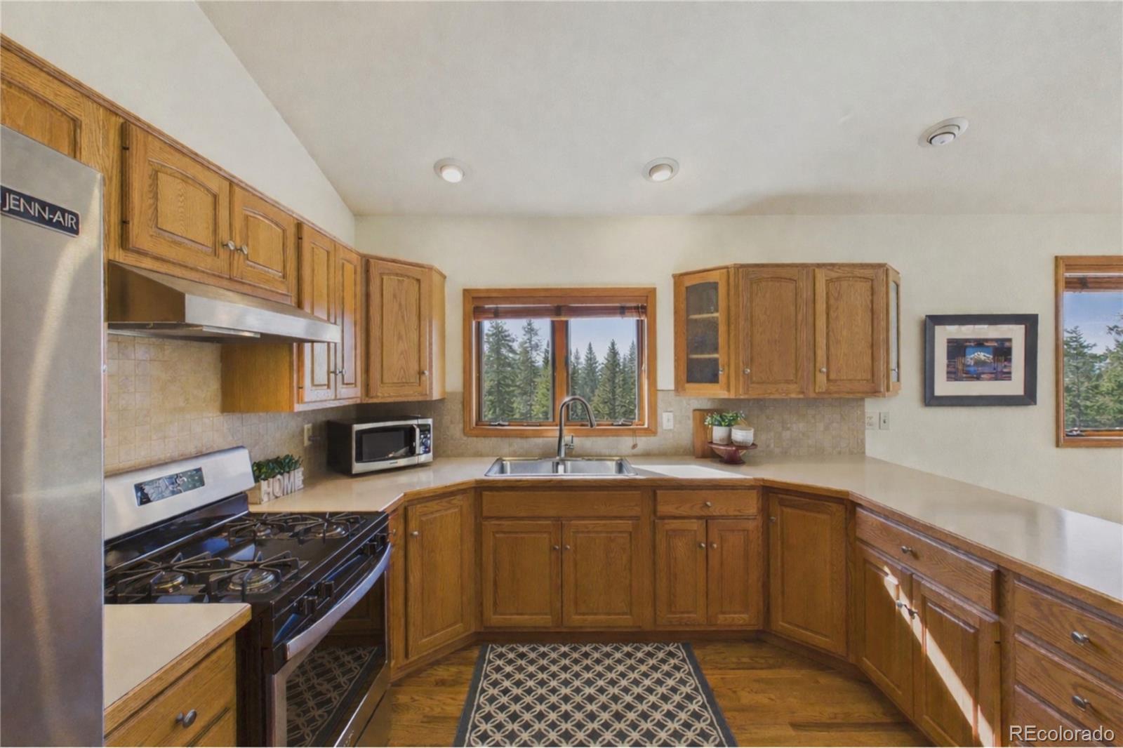 10798 Crystal Way Morrison, CO 80465 - Photo 8 of 36 a kitchen with a sink stove top oven and cabinets