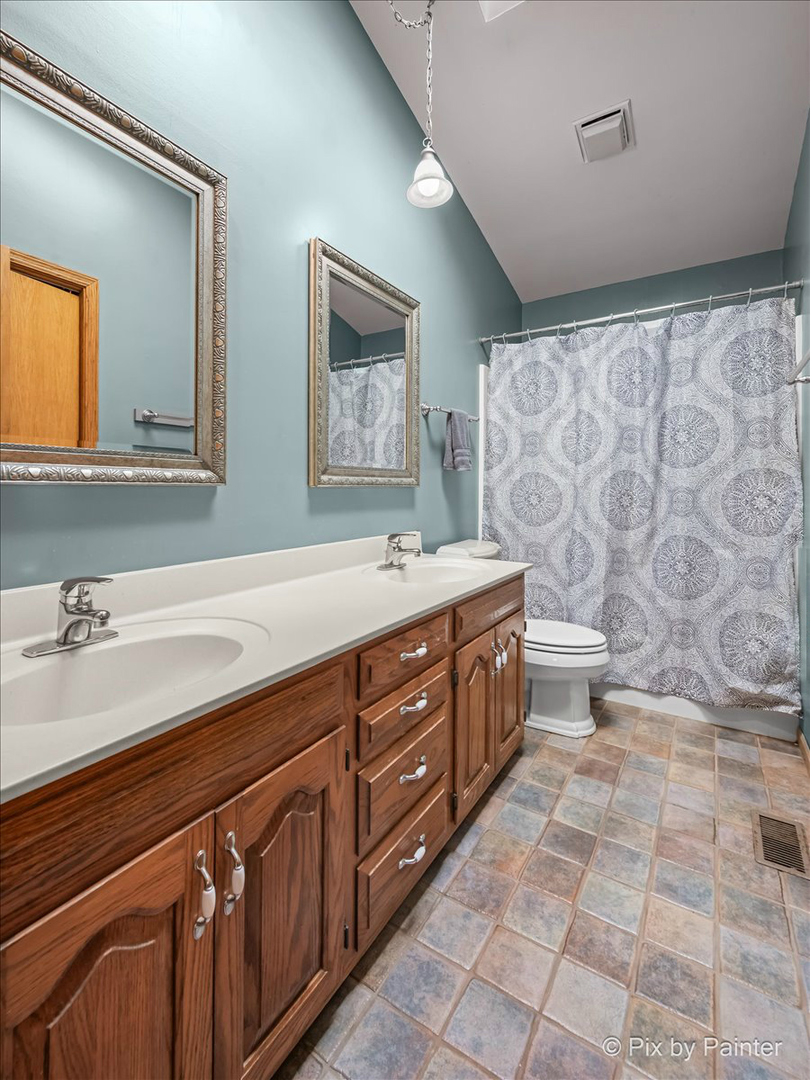 4319 Mc Cauley Road Woodstock, IL 60098 - Photo 27 of 52 a spacious bathroom with a double vanity sink a mirror and a