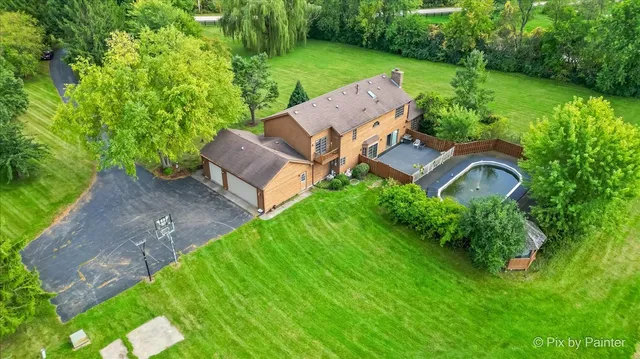 a view of a garden with lake and houses in the back