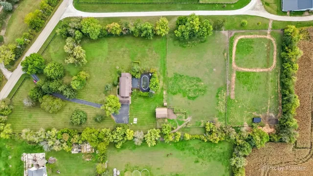 an aerial view of a house with garden space and a swimming pool