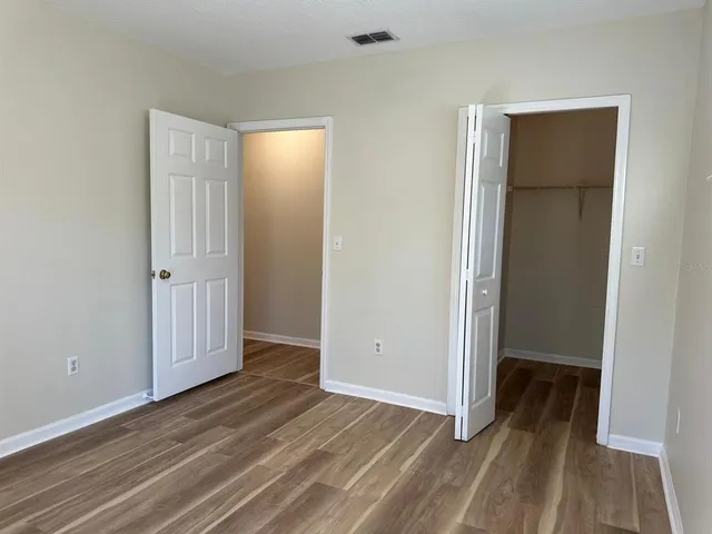 an empty room with wooden floor and closet