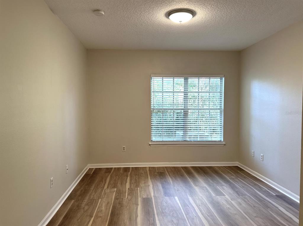 4308 South Kirkman Road, Unit 1 Orlando, FL 32811 - Photo 20 of 24 an empty room with wooden floor and windows