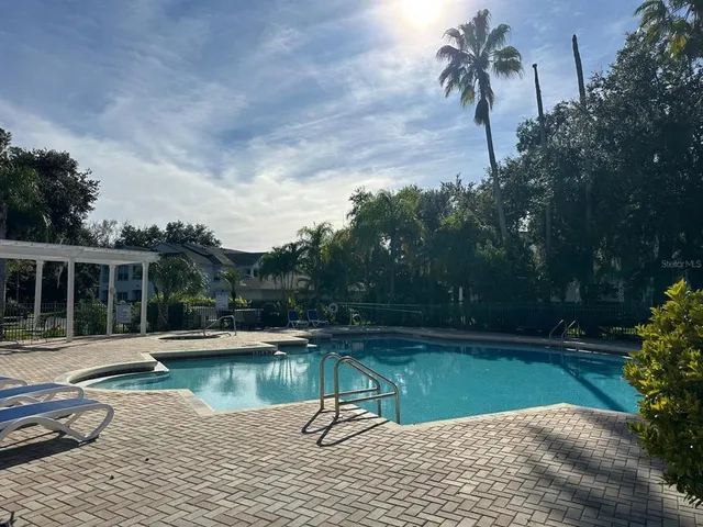 swimming pool with a bench and trees in the background