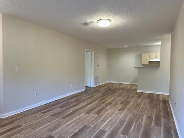 a view of empty room with wooden floor