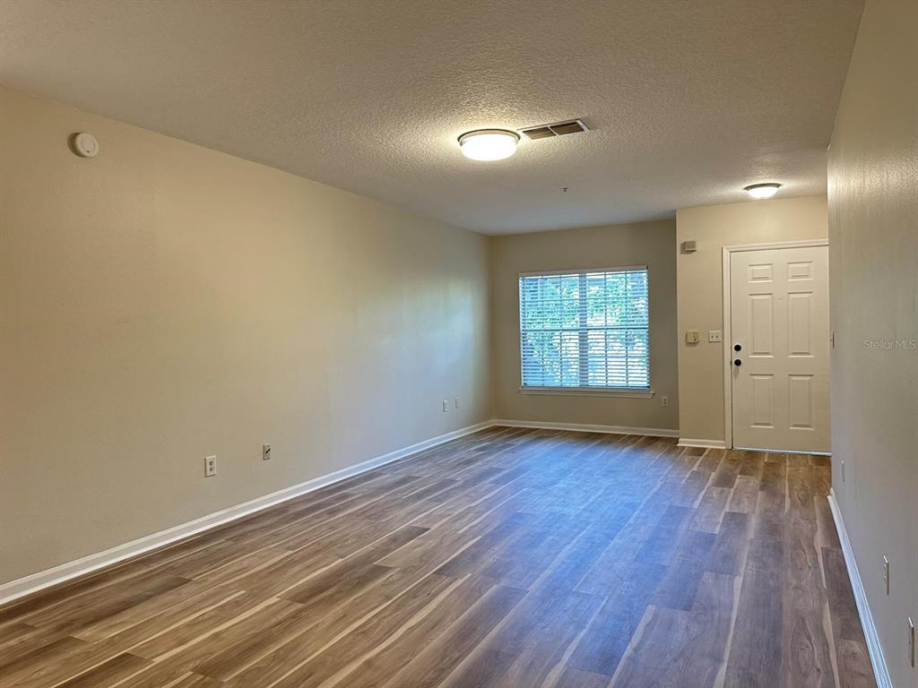 4308 South Kirkman Road, Unit 1 Orlando, FL 32811 - Photo 8 of 24 a view of empty room with wooden floor and fan
