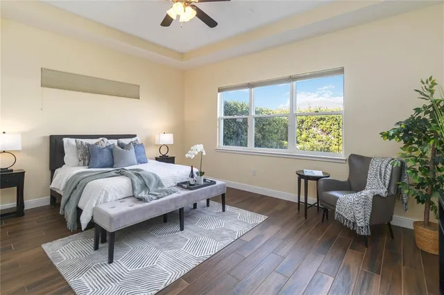 a bedroom with a bed a chair and a potted plant