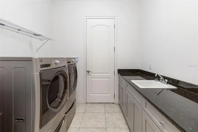 a utility room with sink dryer and washer