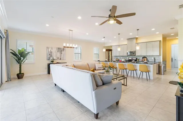 a living room with furniture kitchen view and a chandelier